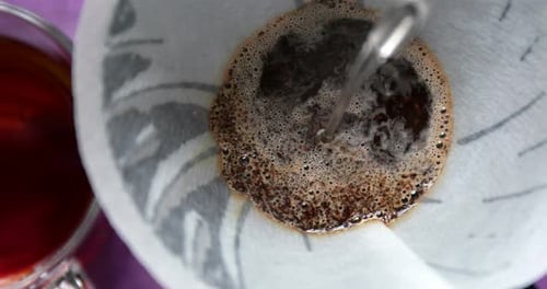 Pouring water into coffee filter close up