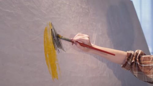 Woman Painting on Canvas with Brush Indoors