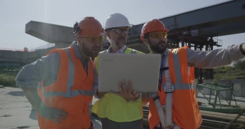 Male Engineers Discussing Plan on Construction Site