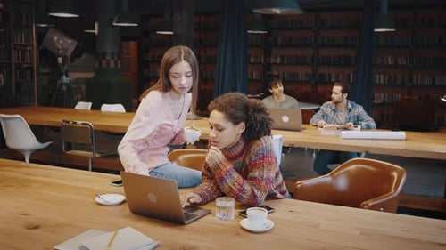 Young Black Female Worker Solve Problem with Help of Colleague