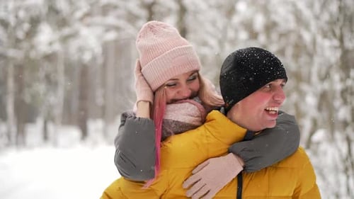 Joyeux couple amoureux marchant dans la forêt d'hiver enneigée, passant des vacances de Noël ensemble. Outdoor