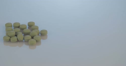 Green Pills Arranged on a White Surface