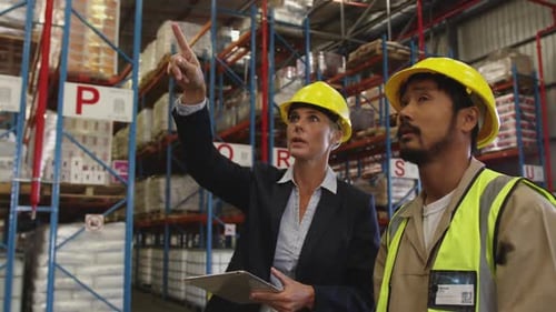 Female warehouse manager and male warehouse worker talking 4k
