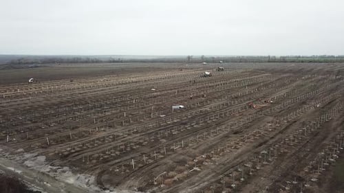 Maschinen und Menschen im Feld auf der Baustelle eines Solarkraftwerks