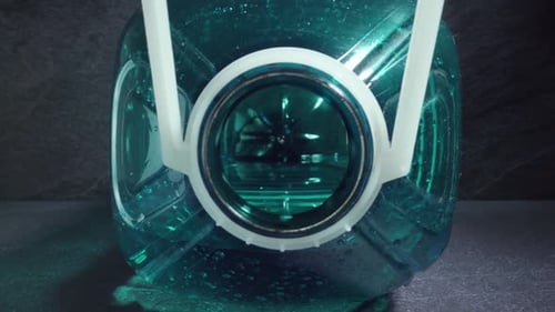 Motion Inside Large Plastic Bottle of Water on Grey Table