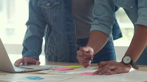 Young Adults Collaborating on Project at Office Desk