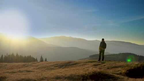 Hiker Reaches Mountain Top at Golden Sunrise