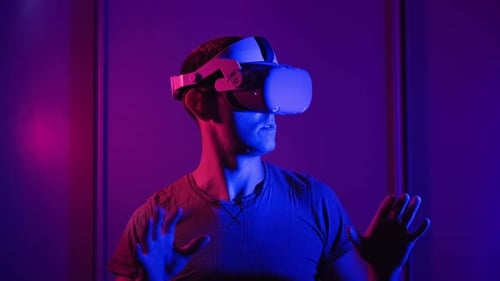 Man Experiences Virtual Reality with Headset in Neon Lighting