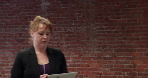 Woman Walks Through Modern Office with Tablet