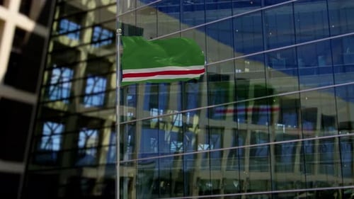 Green and Red Striped Flag Waving on Modern Building Background