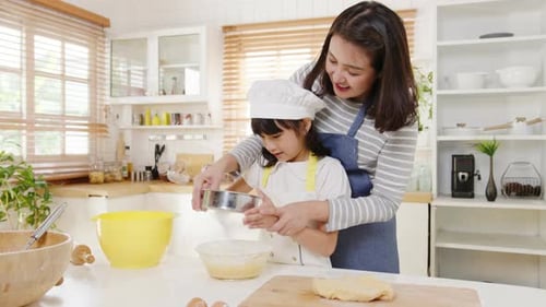 Mother and Daughter Baking Together in Kitchen
