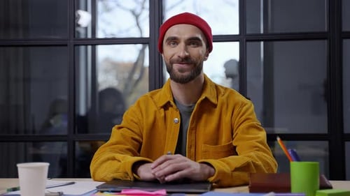 Man Smiling at Desk in Modern Office