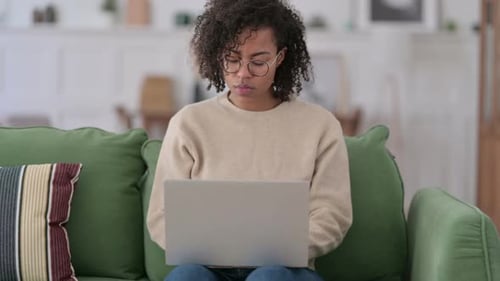 Young Adult Coughing While Using Laptop at Home