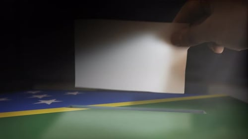 Hand Casting Vote into Ballot Box with National Flag