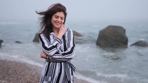 Smiling Woman Posing on a Rocky Beach