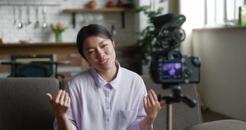Smiling woman vlogging in living room with camera