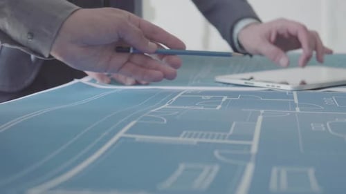 Architect with Pencil and Blueprint on Table