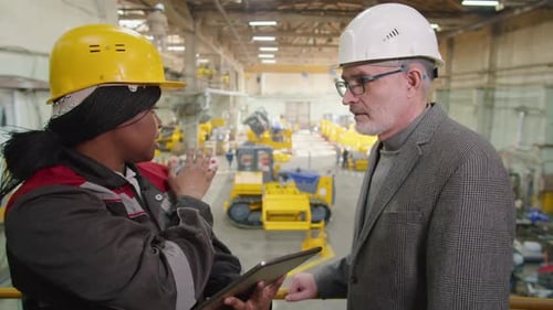 Female Factory Worker and Engineer Discussing Something on Tablet