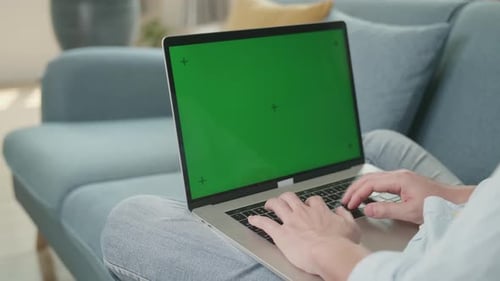 Man Hands Typing On Laptop With Green Screen Mock Up Display At Home Living Room