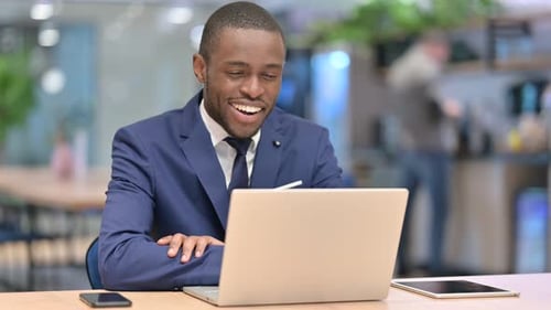 Happy African Businessman Doing Video Call on Laptop in Office