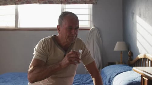 Senior Mann trinkt Wasser zu Hause