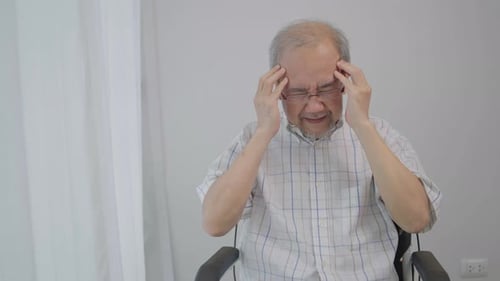 Asian senior man having headache. Stressed and depressed from health problem