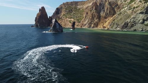 Jet Ski Tows Raft on Blue Ocean Coast