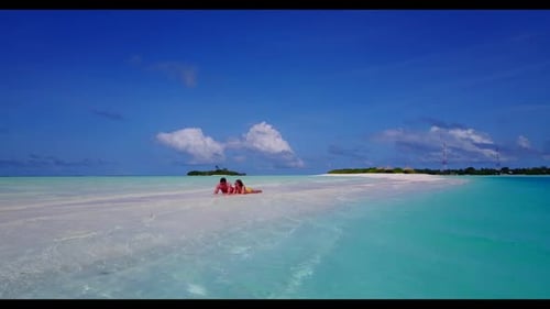 Two lovers sunbathing on luxury shore beach time by blue ocean and white sand background of the Mald