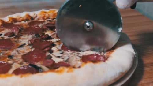 Slicing Delicious Pepperoni and Mushroom Pizza