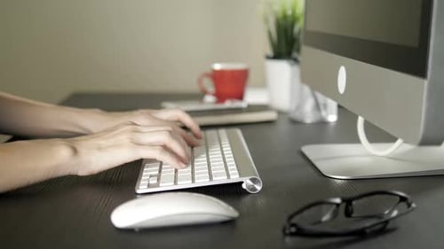 Hands Typing on Keyboard in Home Office