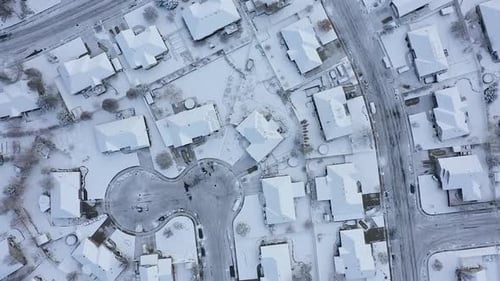 Aerial view looking down at streets and houses covered in snow