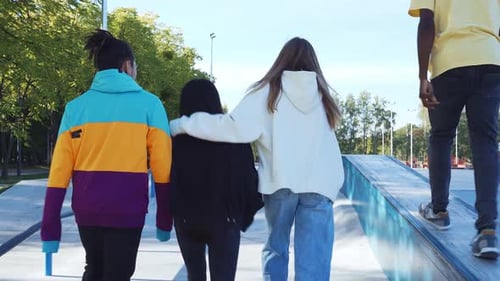 Group of Friends Walking and Jumping at Skatepark