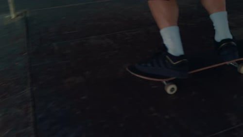 Active Teenager in Sneakers Riding on Skate Board in Modern Urban Skate Park