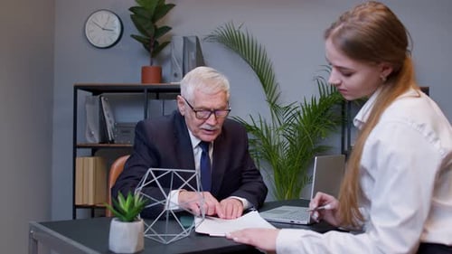 Senior Businessman Company Entrepreneur Ceo Examining Financial Data with Young Woman Colleague