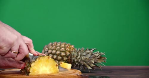 Slicing Ripe Pineapple on a Wooden Board