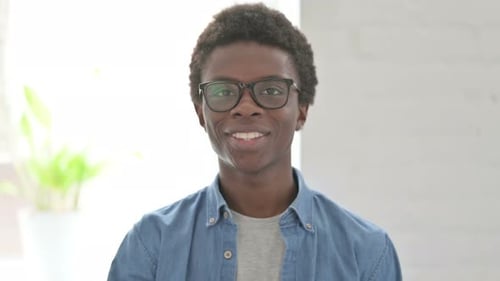 Young Adult Giving Thumbs Up Gesture and Smiling