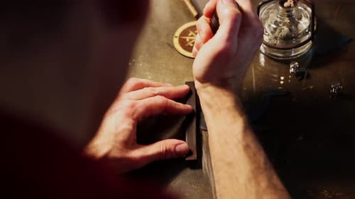 Leather Workshop a Man Cuts the Piece of Pressed Leather with Hot Solder