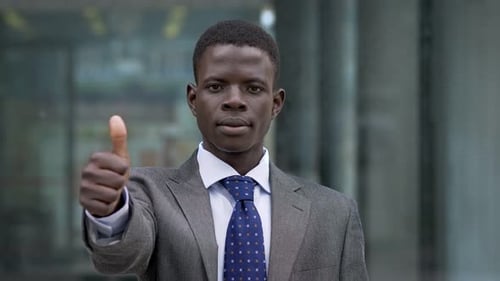 Business Man Gives Thumbs Up in City Setting