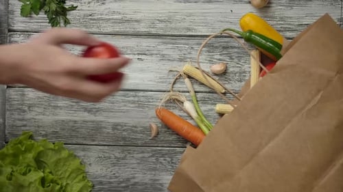 Gente de la cosecha sacando alimentos de una bolsa de papel