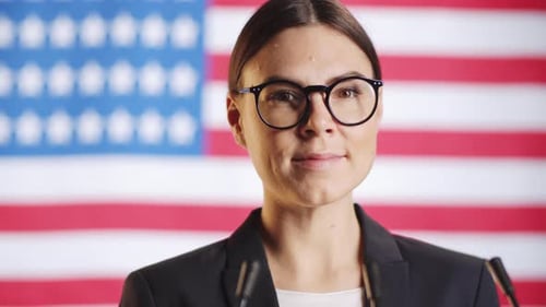 Young Adult Woman Smiling in Front of American Flag