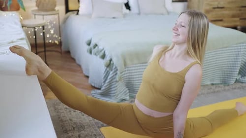 Woman Stretches into Splits on Yoga Mat at Home