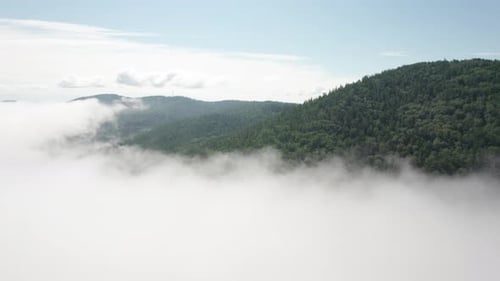 Flying Through the Clouds Above Mountain Tops