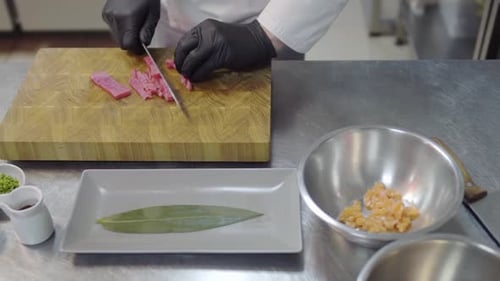 Close Up Hands of Chef in White Restaurant Uniform Cutting Small Salmon Fish