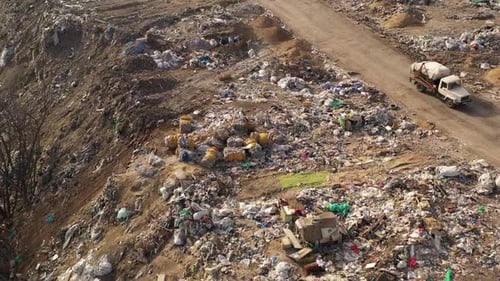 Flight Over Trucks Bringing Waste To a Garbage Pile in Trash Dump. Aerial View of Large Garbage Pile