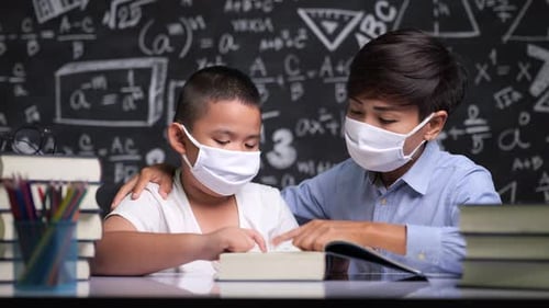 Boy Learning with Teacher in Classroom with Masks