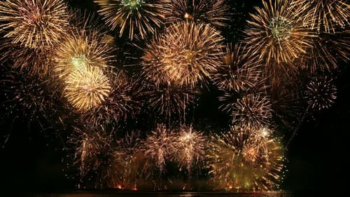 Golden Fireworks Explode at Night Sky Over Water