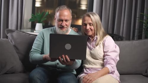 Elderly Couple Video Chatting on Laptop at Home