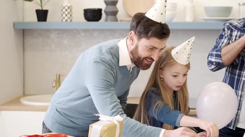 Family Celebrates Birthday with Cake and Balloons