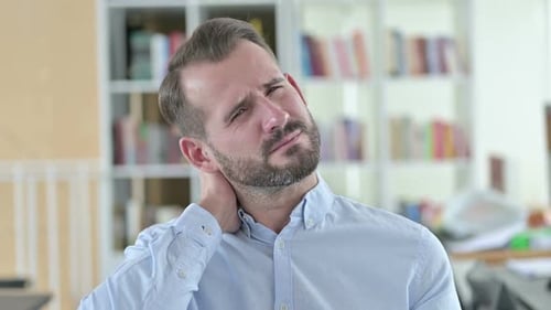 Man Rubs Stiff Neck in Office