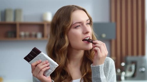 Young Woman Enjoying Dark Chocolate at Home